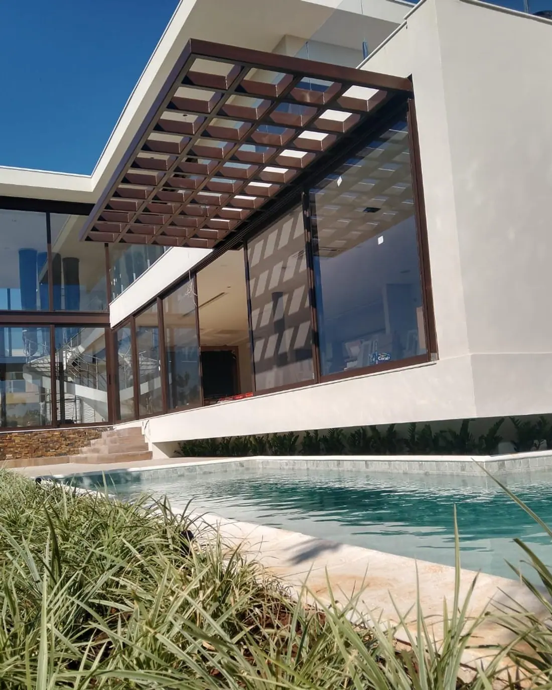 Casa entregue pela AC Engenharia no condomínio Mont Blanc, com fachada branca, pergolado e piscina